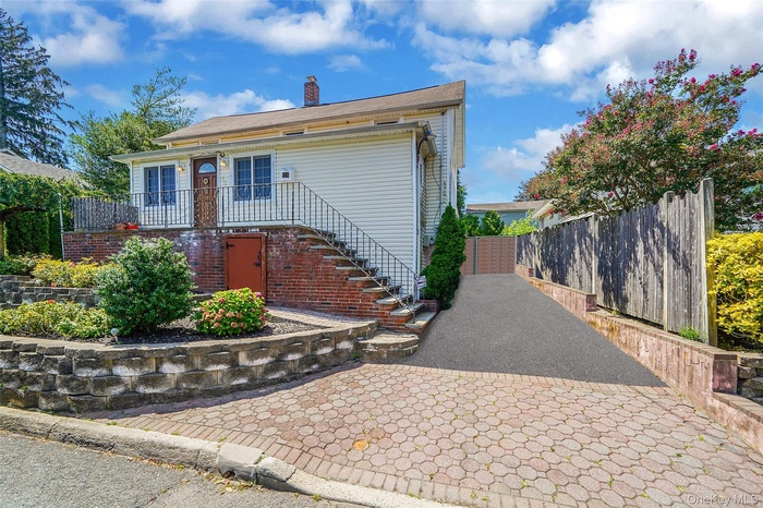 View of front of property featuring stairway, a chimney, and a balcony
