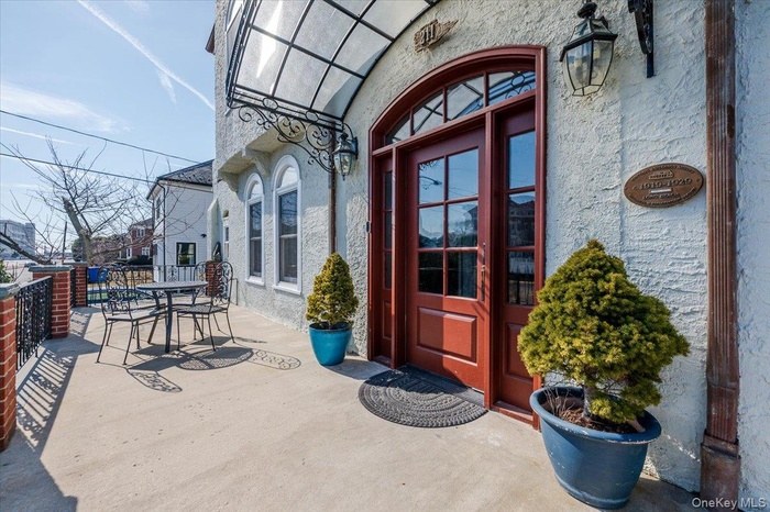 Main Entrance to home featuring awning, Large front deck, fencing, and stucco siding