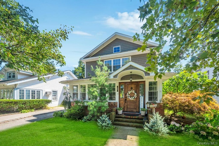 View of front of home featuring a front yard and brick siding