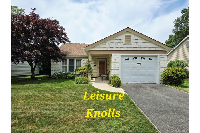 Ranch-style home with a front lawn, driveway, and a garage