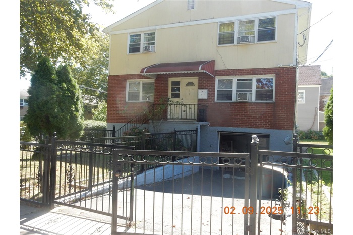Traditional home featuring a fenced front yard, brick siding, and a gate