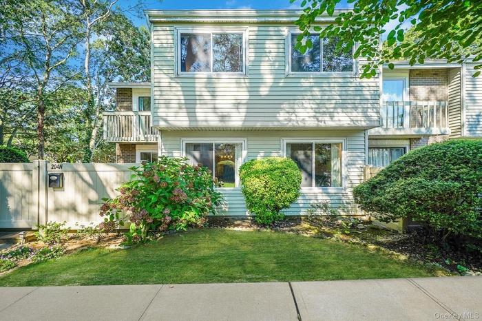 View of front of home featuring a balcony and brick siding