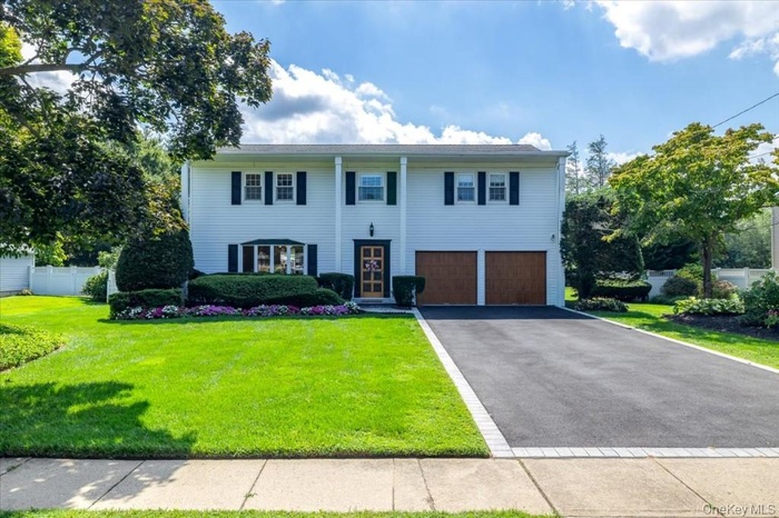 Colonial home with asphalt driveway and a garage