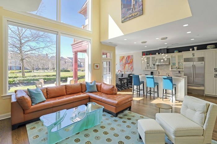Living area featuring wood finished floors, a healthy amount of sunlight, and crown molding