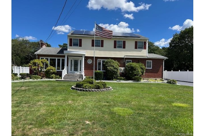 View of front of home featuring brick siding, roof mounted solar panels,