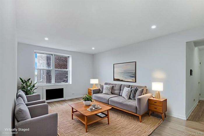 Living area with light wood-style flooring and recessed lighting
