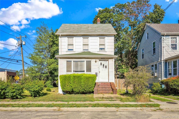 View of front of house with a chimney and roof with shingles