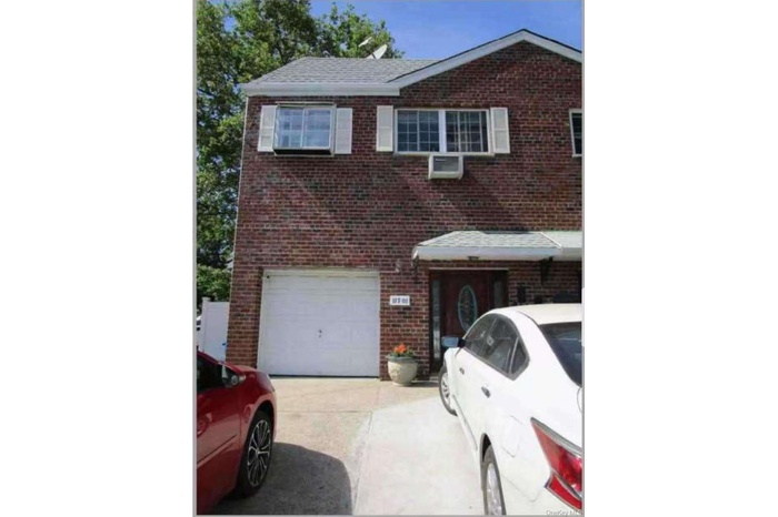 Traditional home featuring brick siding, concrete driveway, and an attached garage