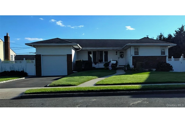 Ranch-style home with an attached garage, driveway, covered porch, and roof with shingles