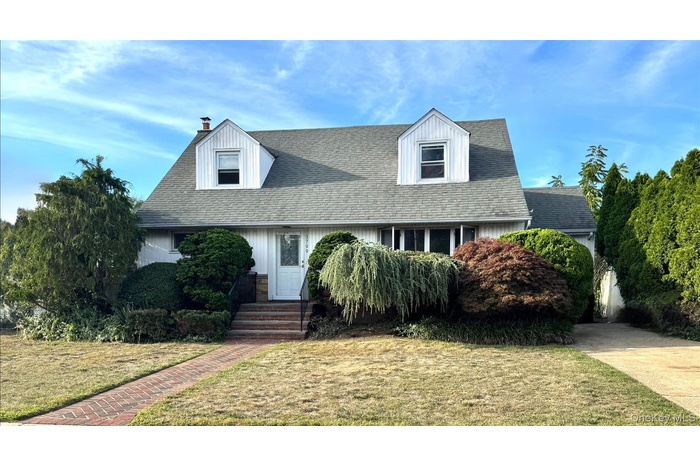 New england style home featuring a front yard and a chimney