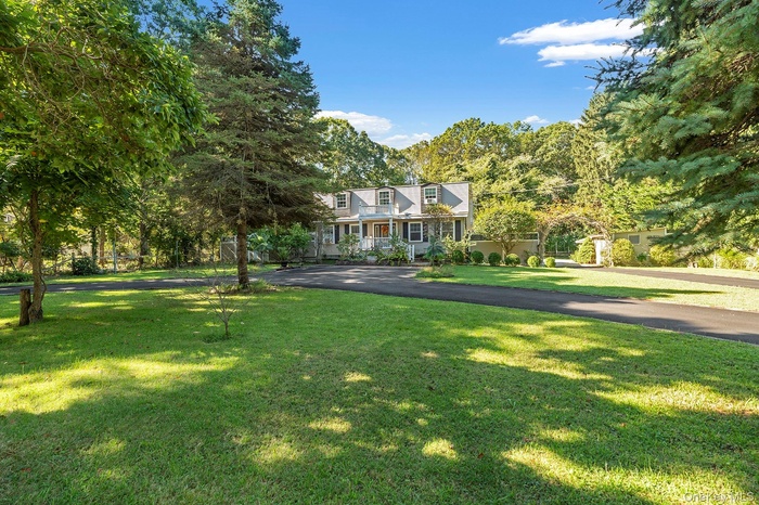 Cape cod-style house featuring a front lawn
