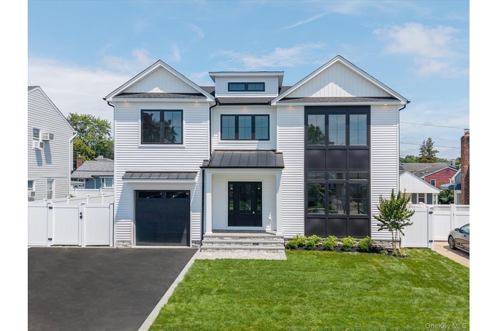 Modern inspired farmhouse with a gate, driveway, and a garage