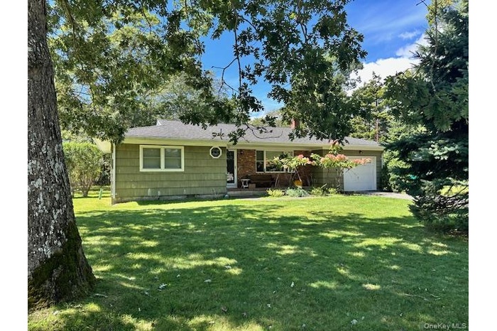Single story home with a garage and a front yard