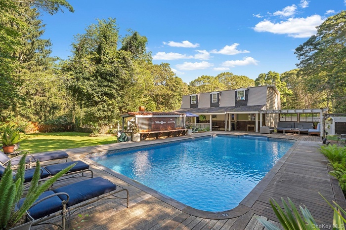 Outdoor pool featuring a patio, a yard, a storage structure, an outdoor hangout area, and a pergola