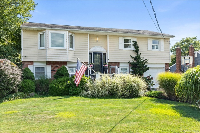 Bi-level home featuring brick siding and a front yard