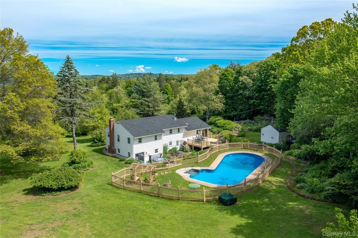 View of pool featuring a forest view and a deck