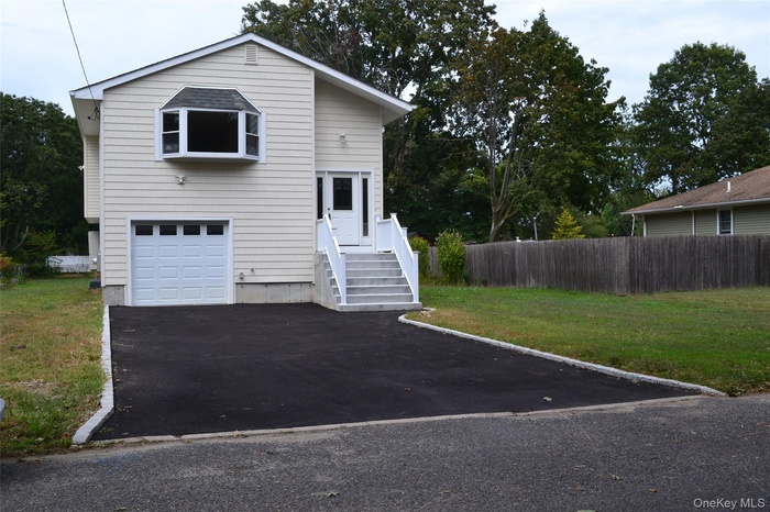 View of front facade with driveway and a garage