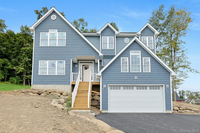 View of front of house featuring driveway and a double door garage