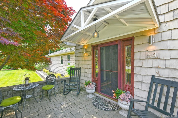 Property entrance with a patio area and a lawn