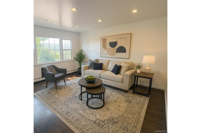 Living room featuring recessed lighting, wood finished floors, and a baseboard heating unit