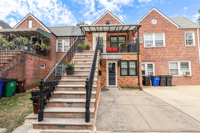 2-Family, Black Accented Brick Home with Striking Stairway Leading to the Second Floor Entrance and Covered Patio.