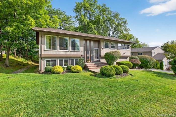 Bi-level home featuring a front lawn