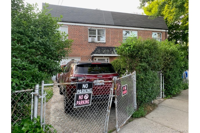 View of front of house with brick siding and a gate
