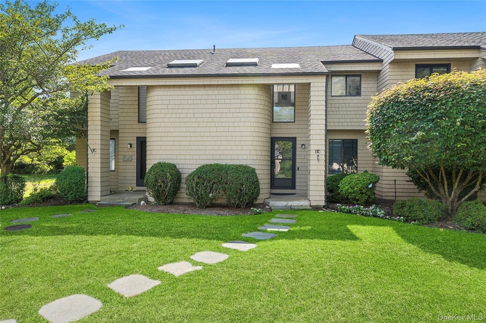 View of front of property with a shingled roof and a front lawn