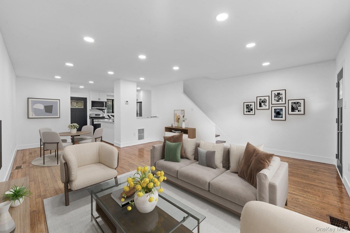 Living room with recessed lighting, light wood-style flooring, and stairs
