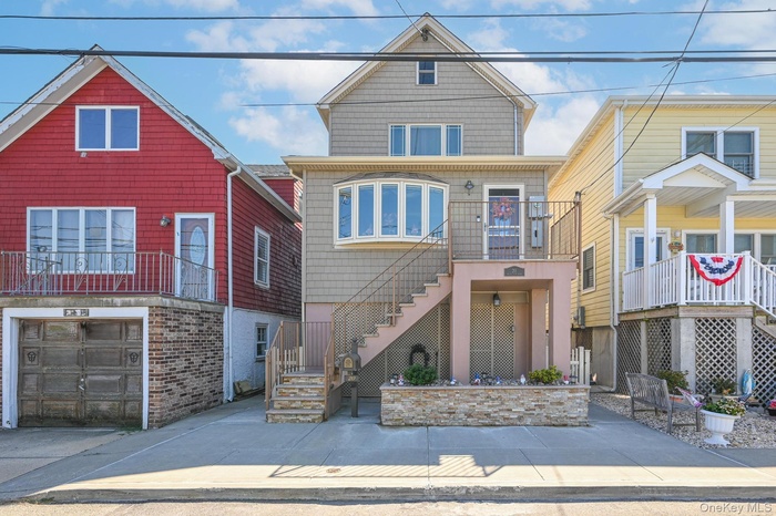 View of front facade featuring stairs and a garage