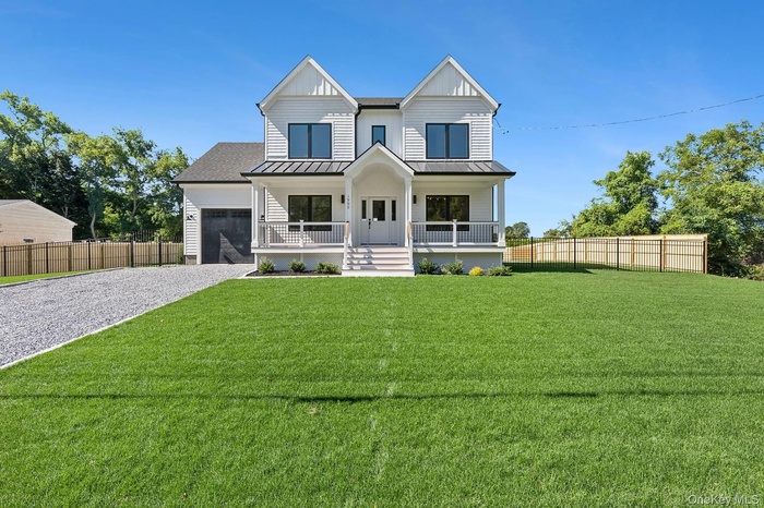 Modern farmhouse style home featuring covered porch, driveway, board and batten siding, a standing seam roof, and a garage
