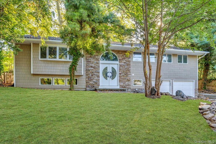 Split foyer home with a garage and a front lawn