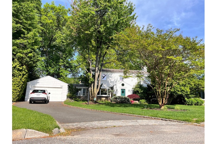 View of front of house with a front yard and a detached garage
