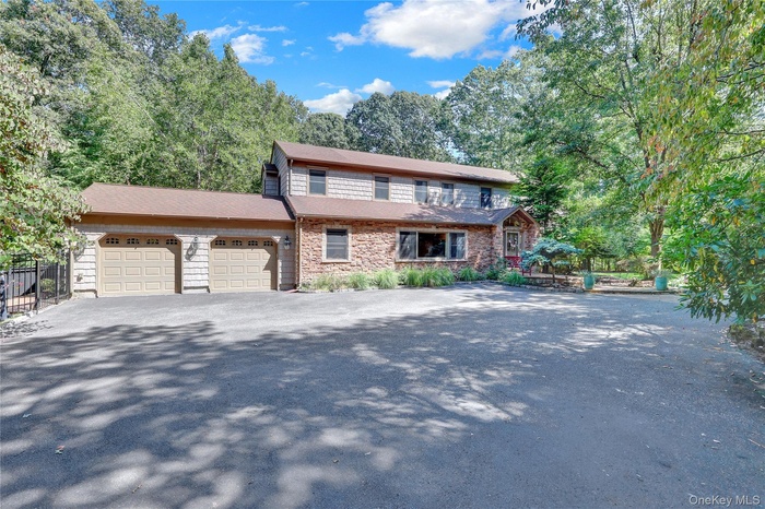 View of front of home featuring asphalt driveway and an attached garage