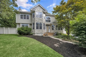 Welcome to 22 Whispering Woods Drive, located in the sought after Smithtown School District !