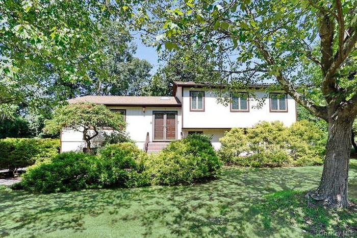 Split level home with a front lawn