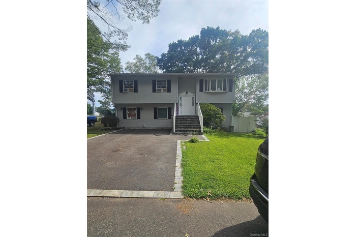 Bi-level home with a front lawn and driveway