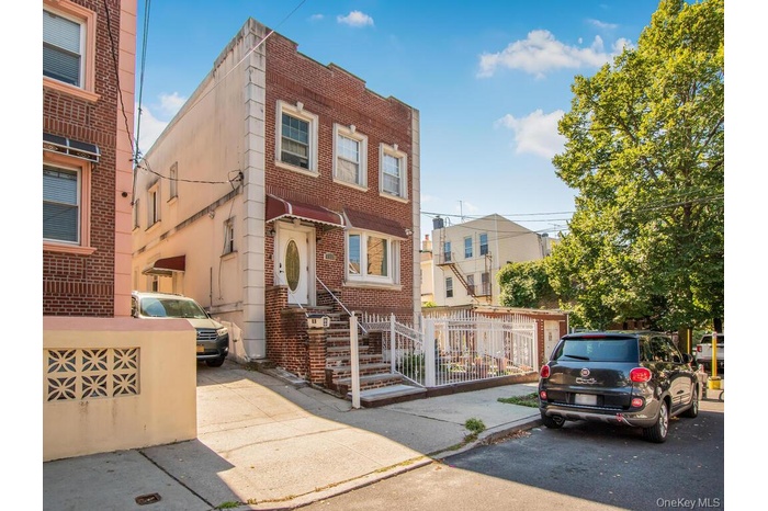 View of front of house featuring a fenced front yard, brick siding, and a residential view