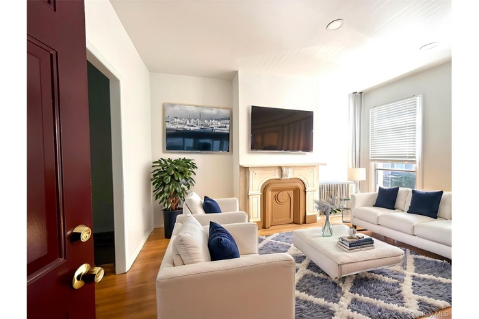 Living area with wood finished floors and recessed lighting