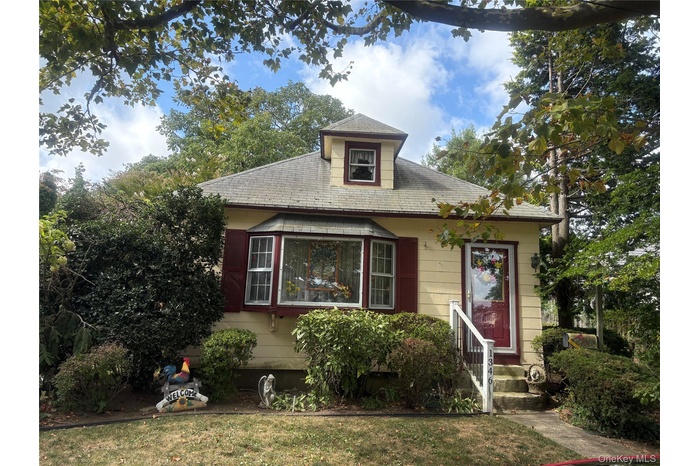 Bungalow-style home with roof with shingles and a front yard