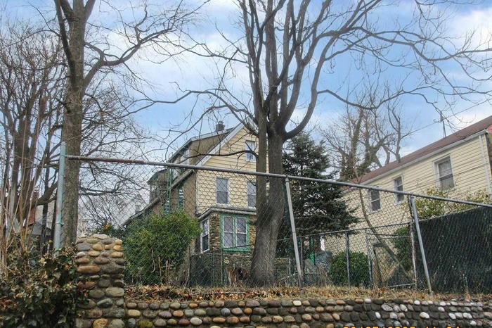 View of side of property with a chimney and fence