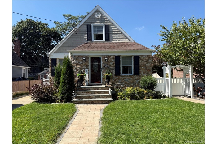 View of front of home with stone siding and a gate to Access side door and Backyard