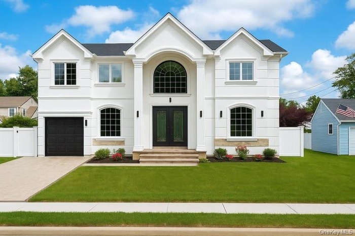 View of front facade featuring stucco siding, concrete driveway, a garage, and french doors