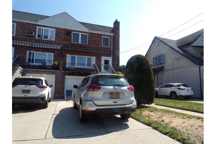 View of front of home featuring brick siding, a chimney, a garage, and concrete driveway