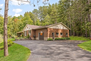 Manicured gardens, towering trees, and a backyard oasis set the stage for this beautifully maintained bungalow on nearly an acre of land.