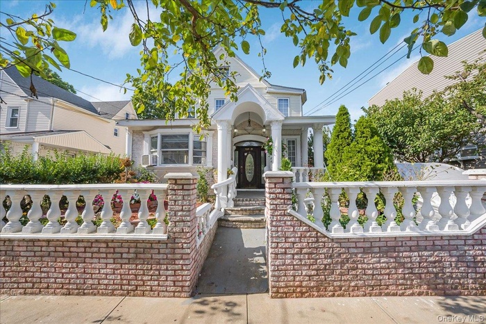 View of front of house with a porch and brick siding