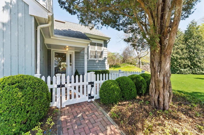 Entrance to property with fence, a gate, and roof with shingles