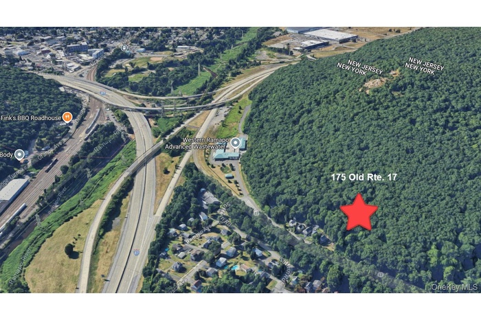 Aerial view of property's location with a highway and a heavily wooded area