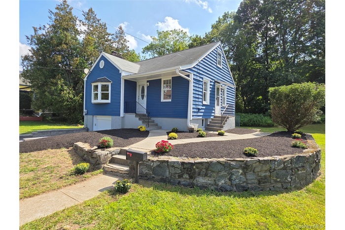 View of front of property with a front lawn and a garage