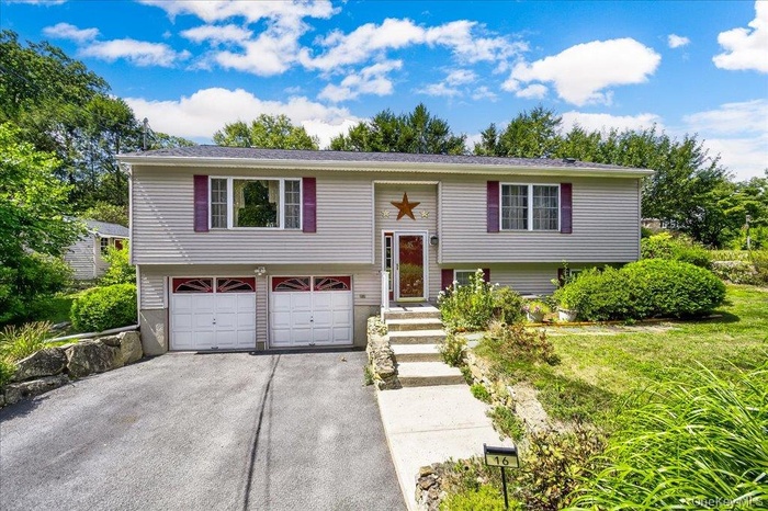 Bi-level home with driveway and a garage